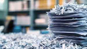 Stack of documents with shredded paper around it